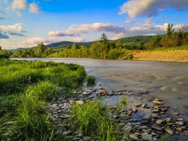 Gün batımında bir dağ nehrinin manzarası