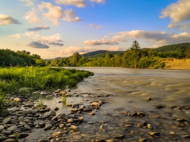 Gün batımında bir dağ nehrinin manzarası