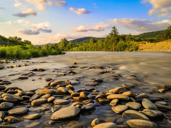 Gün batımında bir dağ nehrinin manzarası