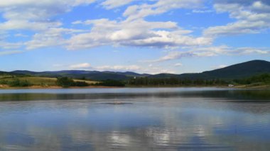 Bir adam dağ gölünde yüzer.