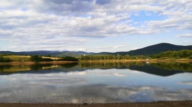 Bir kırlangıç sürüsü gölün yüzeyinde avlanır.