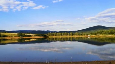 Yaz günbatımında bir dağ gölünün zaman turları