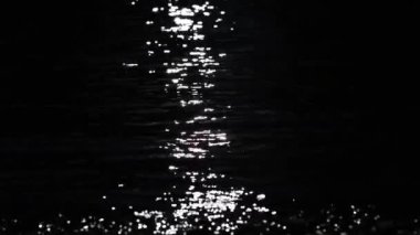 Sunny path on the waves of a mountain river in a dark key