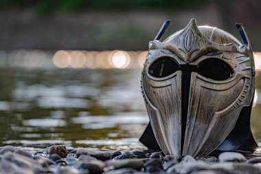 Bir dağ nehrinde gladyatör miğferiyle mecazi kurulum.