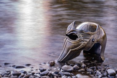 Bir dağ nehrinde gladyatör miğferiyle mecazi kurulum.