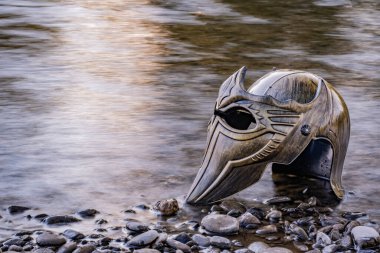 Bir dağ nehrinde gladyatör miğferiyle mecazi kurulum.