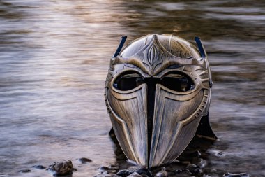 Bir dağ nehrinde gladyatör miğferiyle mecazi kurulum.