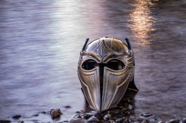 Bir dağ nehrinde gladyatör miğferiyle mecazi kurulum.