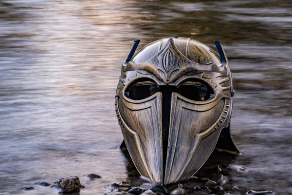 Bir dağ nehrinde gladyatör miğferiyle mecazi kurulum.