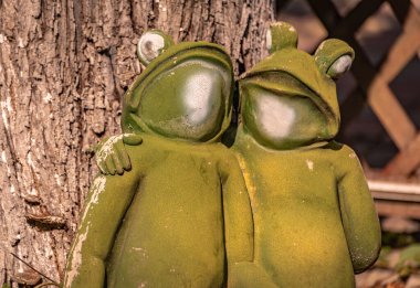 Arka bahçede kurbağaları kucaklayan heykel.