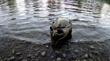 Bir dağ nehrinde gladyatör miğferiyle mecazi kurulum.