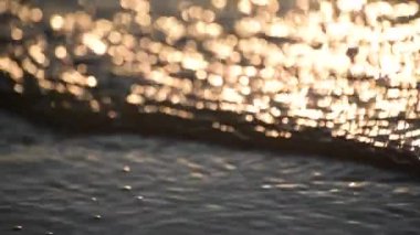 The surf of the lake at golden hour