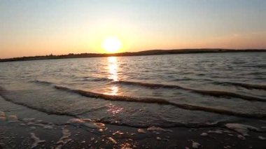 The surf of the lake at golden hour