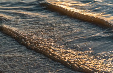 The surf of the lake at golden hour