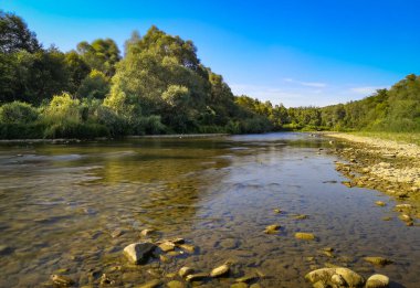 Gün batımında bir dağ nehrinin manzarası