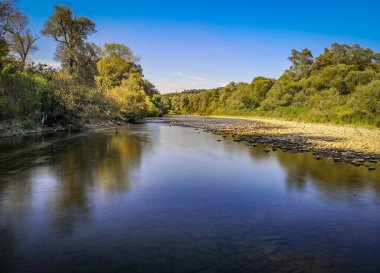 Gün batımında bir dağ nehrinin manzarası