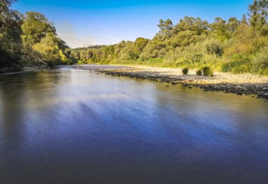 Gün batımında bir dağ nehrinin manzarası