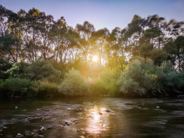 Gün batımında bir dağ nehrinin manzarası