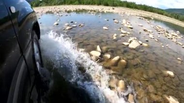 Yazın bir dağ nehrinde SUV