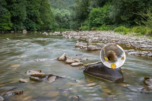 Landscape with French horn in a mountain river