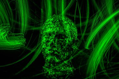 Işıkla özetlenmiş bir adamın mistik yüzü.