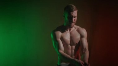 Bir atlet ipe atlıyor. Ortalıkta sallıyor. Kardiyo eğitimi. Kaslarının nasıl çalıştığına bak. Turuncu ve yeşil ışık onun üzerinde parlıyor. 4K
