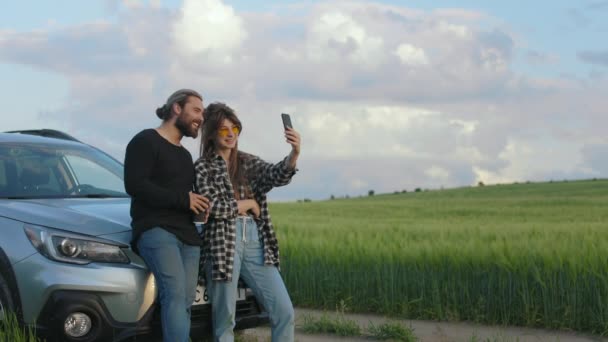 Kırsal kesimde cep telefonundan görüntülü arama yapan genç bir çift. — Stok video