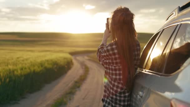 Mujer en ropa casual tomando fotos de la puesta del sol en el móvil — Vídeo de stock