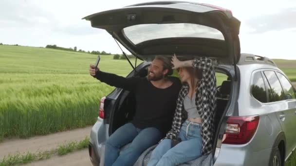 Pár má videohovor na mobilu, zatímco sedí v autě — Stock video