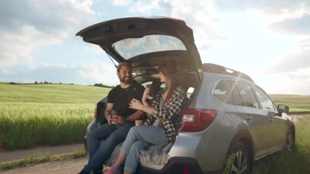 Positive man and woman sitting in car at countryside — Stockvideo