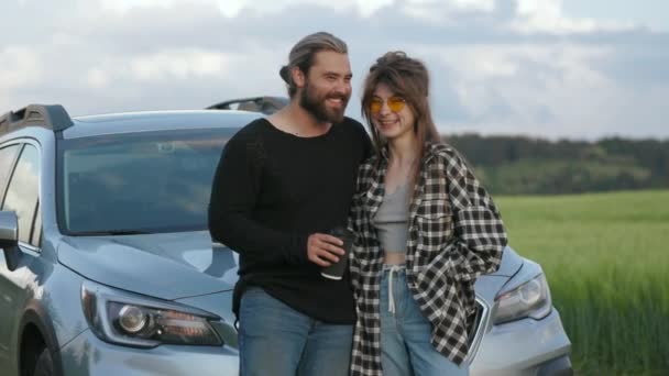 Couple embracing and smiling near modern car among field — Stock Video