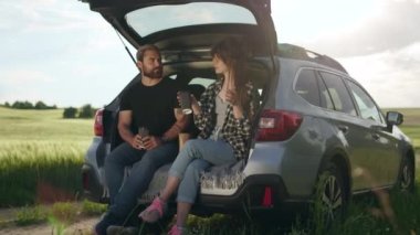 Araba gezisi sırasında kahve molası veren çift.
