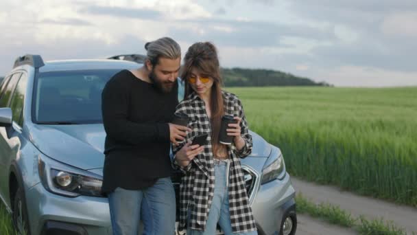 Couple using mobile while standing near car outdoors — Stock Video