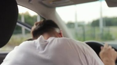Şoför koltuğunda bir adam arabada oturuyor. Maskesini çıkarıyor. Arka koltuklardan ateş ediyorlar. 4K 50fps