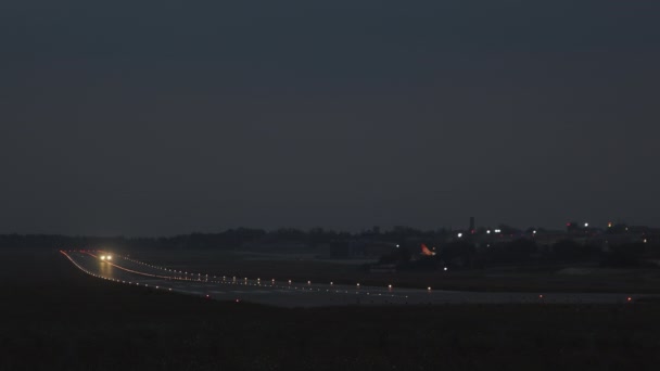 A passenger plane is taking off from the runway. The plane is taking to the sky. Its night outside and you can see the airport lights. 4K 50fps — Vídeos de Stock