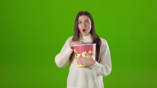 Woman eating popcorn and watching film in studio — Stockvideo