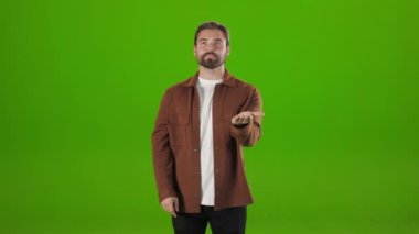 Man standing over green background and gesturing in air