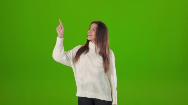 Woman looking up and pointing finger to side with copy space — Stock Video