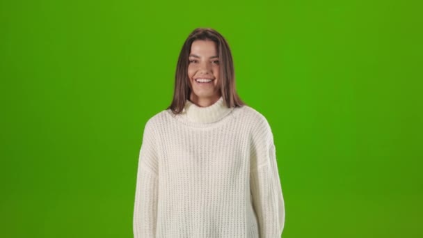 Молода жінка з щирою посмішкою на обличчі позує в студії — стокове відео