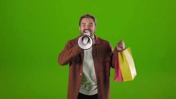 Muž drží nákupní tašky a křičí v reproduktoru — Stock video