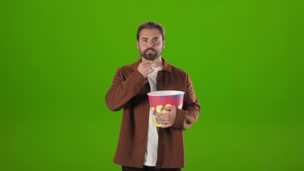 Hombre comiendo palomitas de maíz y asustándose mientras ve la película — Vídeo de stock
