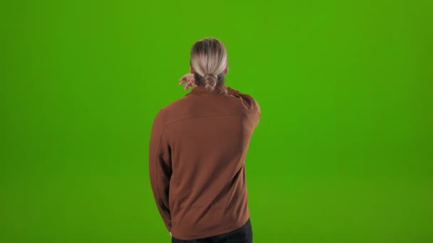 Назад вигляд людини, що жестикулює в повітрі на зеленому фоні — стокове відео