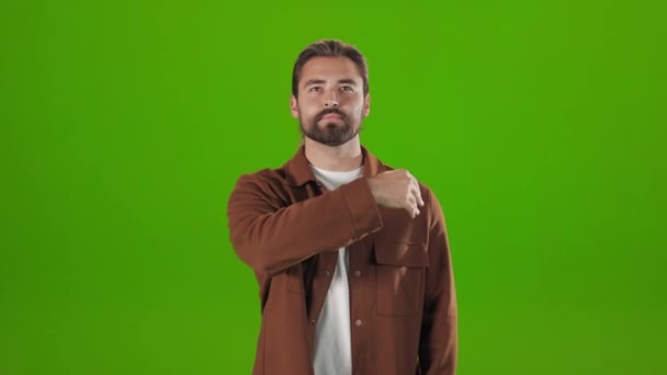 Focused man scrolling with palm in air over green background — Video Stock