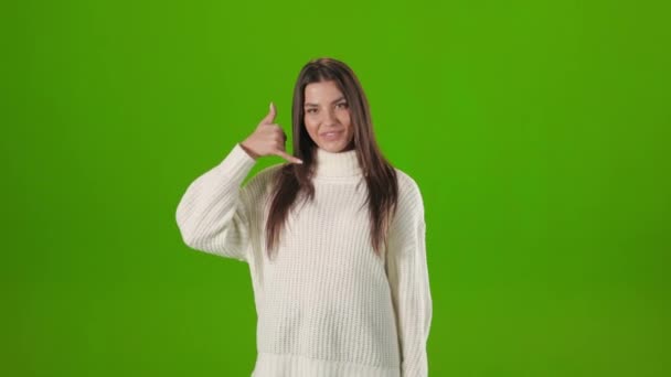 Donna mostrando mi chiamano gesto su sfondo verde — Video Stock