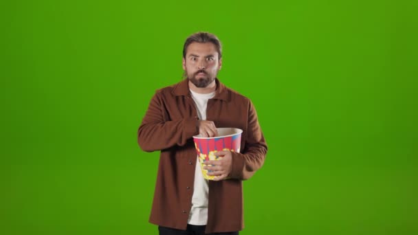 Hombre comiendo palomitas de maíz y viendo películas interesadas — Vídeo de stock