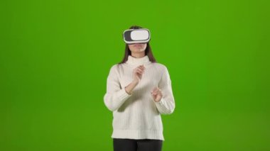Woman touching air while using VR headset in studio