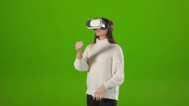 Kadın VR gözlüğü takarken sürgülü hareket yapıyor.