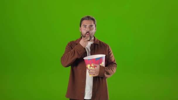 Фокусований чоловік їсть попкорн під час перегляду фільму в студії — стокове відео