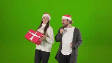 Mutlu çift stüdyoda Noel hediyesiyle dans ediyor.