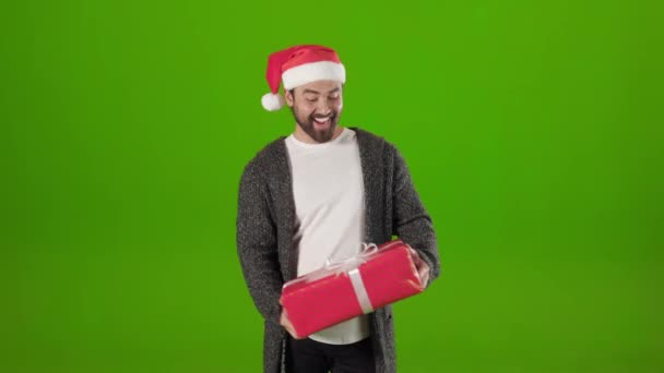 Sorrindo homem em Papai Noel vomitando presente de Natal — Vídeo de Stock